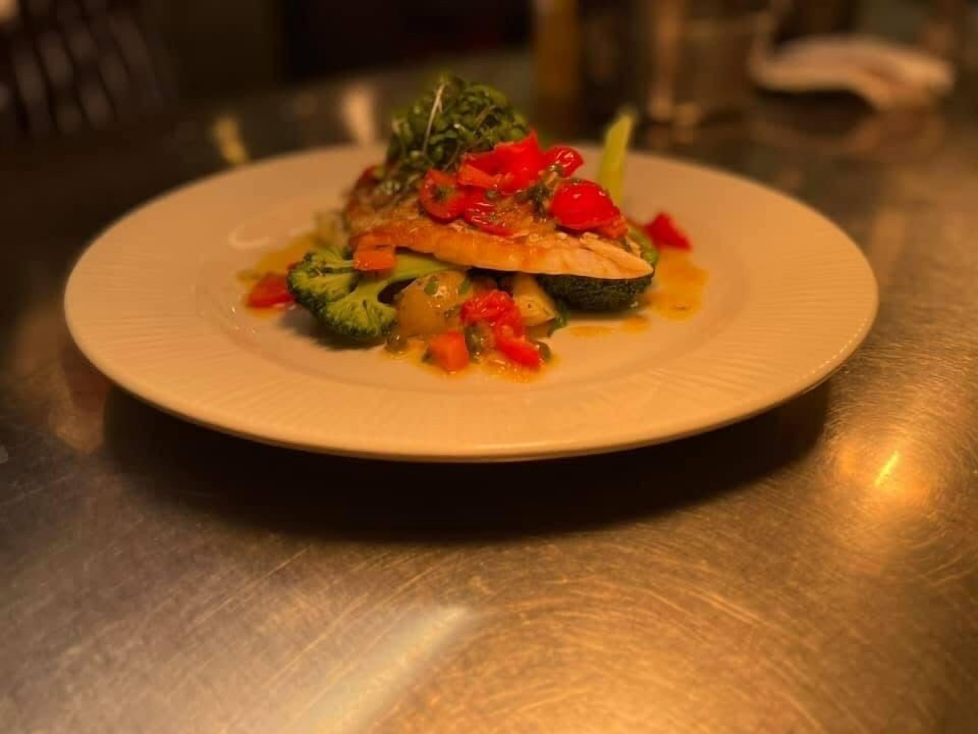 Une assiette de nourriture contenant des légumes et un morceau de viande, le tout présenté sur une assiette blanche.