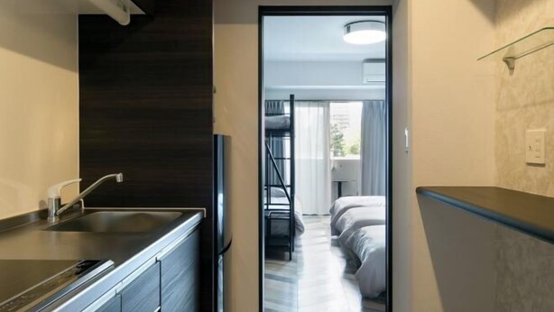 Ein modernes Hotelzimmer mit Küchenzeile, einer Treppe und einem Bett.