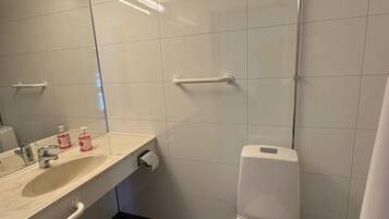 Een douche, handdoeken, zeep, toiletpapier