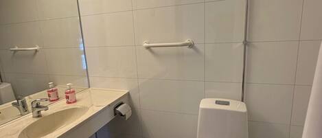 Een moderne badkamer met een wit wastafelmeubel, spiegel en toilet.