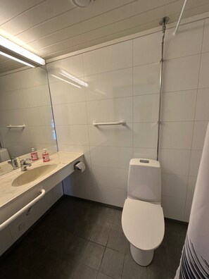 Een douche, handdoeken, zeep, toiletpapier