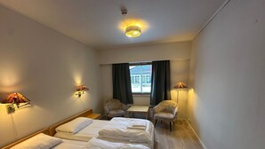 A hotel room with two beds, a desk, two armchairs, and a window with curtains. - Bjorliheimen Fjellhotell-Hotellrom (Lesja)