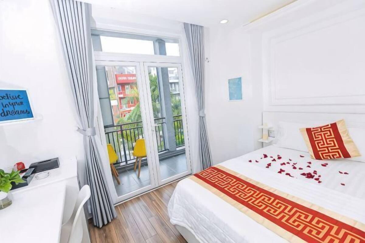Ein Hotelzimmer mit Bett, Schreibtisch, Stuhl, Balkon und Blick ins Freie.