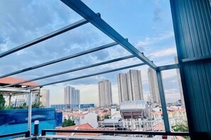 A view through a metal-framed structure with high-rise buildings in the background. - Phu Gia Hotel 99-101 Him Lam (Ho Chi Minh City)
