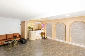 A hotel reception area with a reception desk, a sofa, and a coffee table. - Phu Gia Hotel 99-101 Him Lam (Ho Chi Minh City)