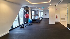 Ein Fitnessstudio mit Laufbändern, Gymbällen und Kurzhanteln.