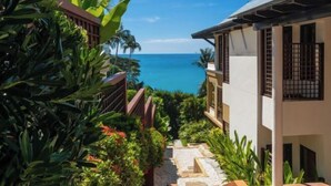 A pathway leading to a building with a view of the ocean. - Boutique 5 Bedroom Seaview Pool Villa Kata Beach Phuket Warm Plus (Phuket)