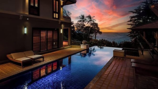 A modern house with a swimming pool, a patio, and a view of the ocean at sunset. - Boutique 5 Bedroom Seaview Pool Villa Kata Beach Phuket Warm Plus (Phuket)