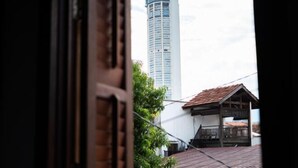 A view of a tall building with a modern design, a traditional wooden structure with a tiled roof, and a glimpse of a window frame. - Lumut Heritage - a walk to Armenian St Art & Cafes (George Town)