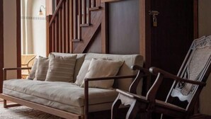 A sofa in a room with a wooden staircase and a door. - Lumut Heritage - a walk to Armenian St Art & Cafes (George Town)