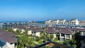 A resort with multiple bungalow-style buildings, a pool, and a view of the ocean. - Aurora Bao Anh Hotel (Binh Kien)