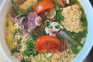 Een kom ramen met diverse toppings, zoals noedels, groenten en vlees.
