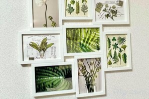 A wall with multiple framed botanical illustrations. - YMK Oshiage 4B (Tokyo)