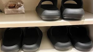 A shelf with pairs of black slip-on shoes. - YMK Oshiage 4B (Tokyo)