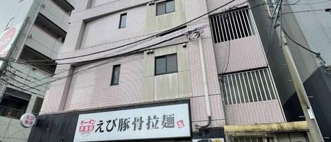 A multi-story building with a storefront featuring a sign in a foreign language.