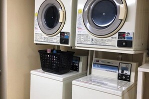 A laundry facility with two front-loading washing machines and a dryer. - Shin-Osaka 1005 (Osaka)