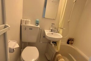 Een badkamer met toilet, wastafel en bad.