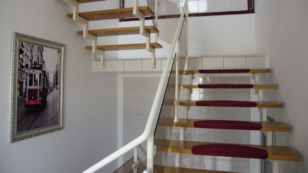 A staircase with wooden steps and red grips, leading to an upper level. - Hotel Rosenhof am Main (Offenbach am Main)