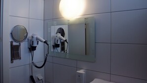 A bathroom with a hairdryer and a mirror. - Hotel Rosenhof am Main (Offenbach am Main)