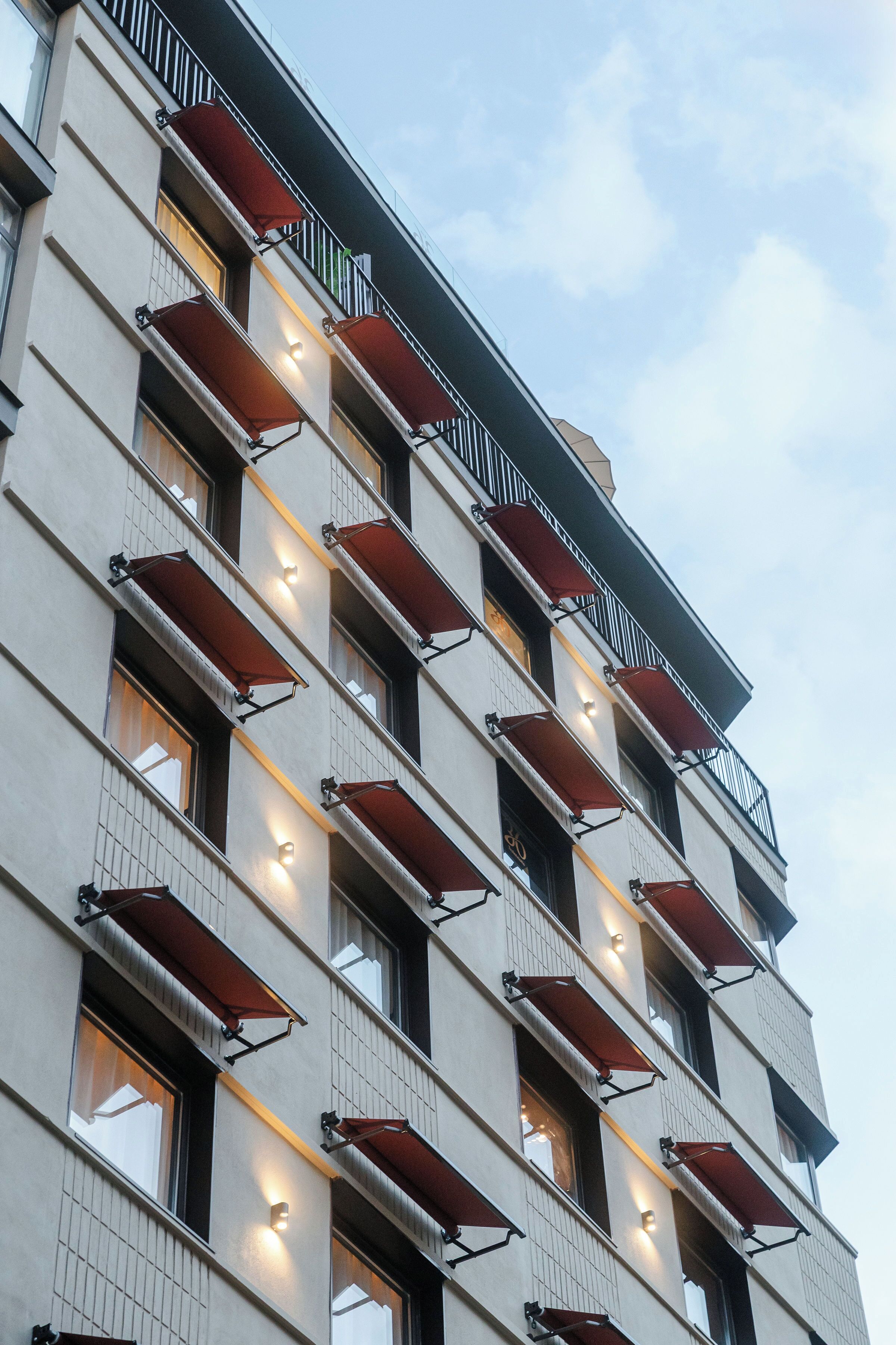 A multi-story building with balconies and exterior lighting.