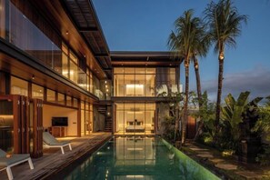 A modern house with a swimming pool, large windows, and a well-lit interior. - Villa Dayu (Bali)