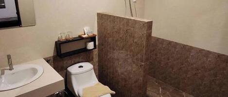 A bathroom with a toilet, sink, and a towel rack.