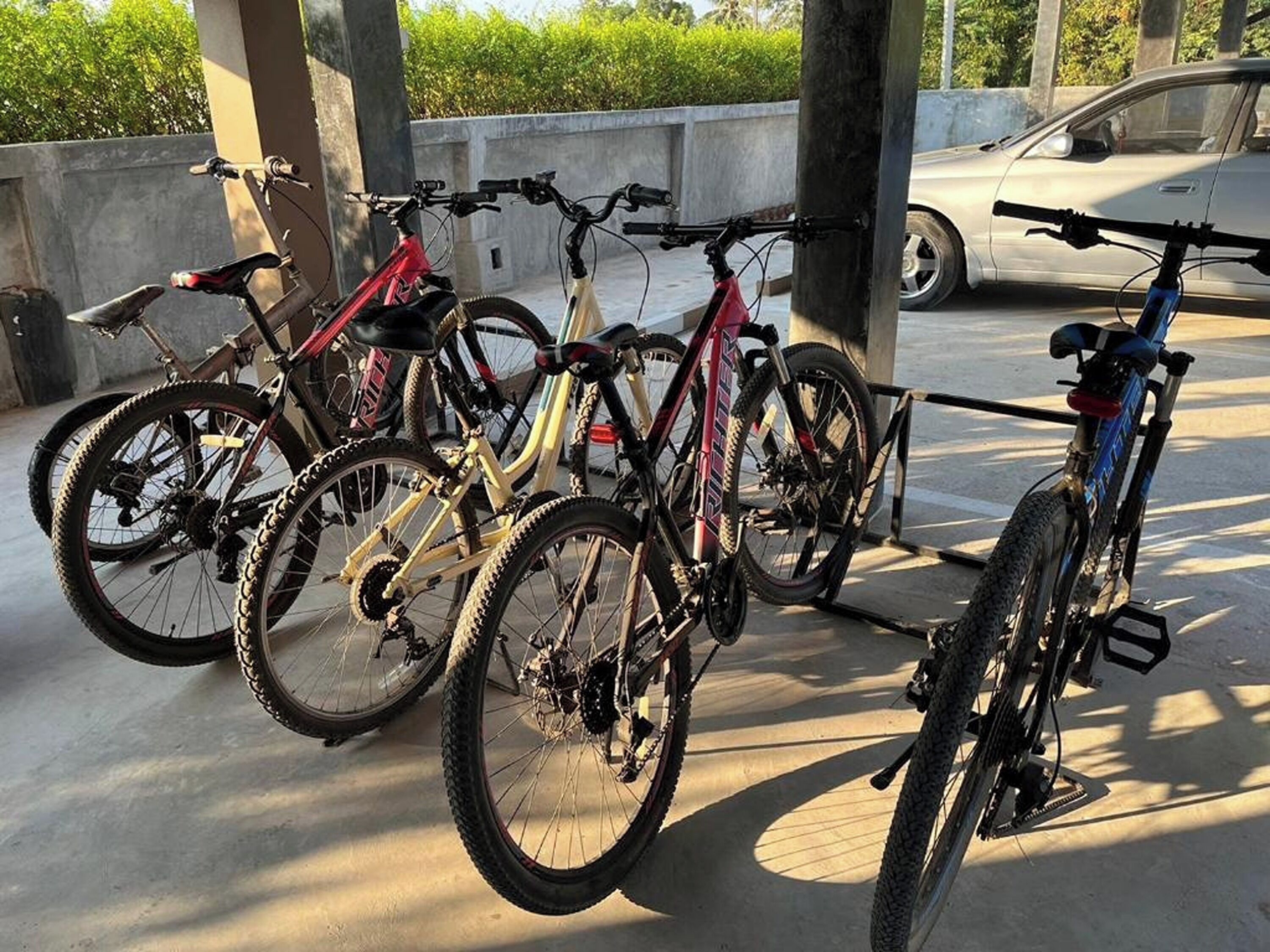A parking area with bicycles and a car.