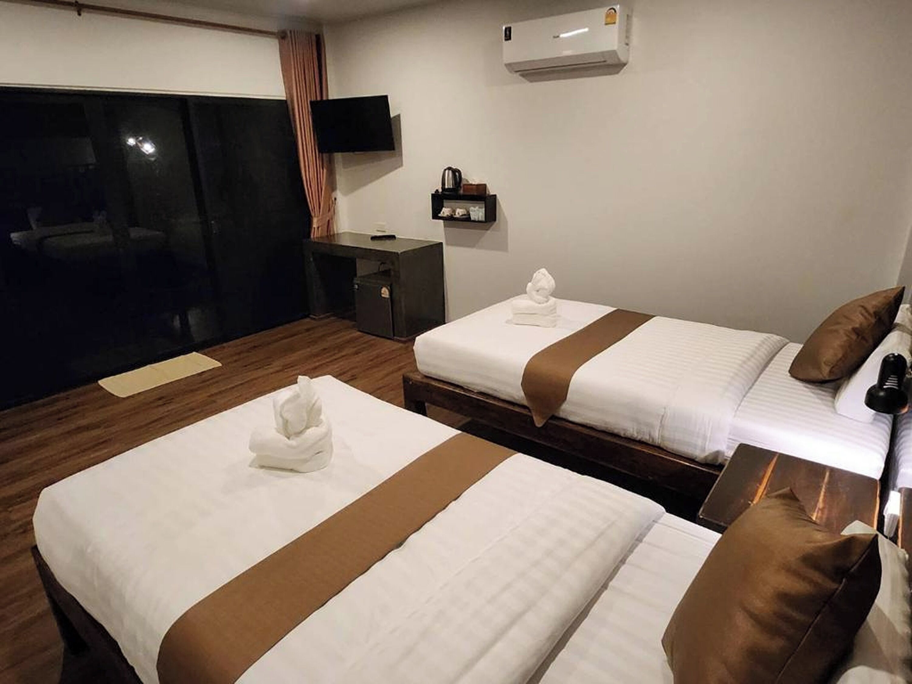 Une chambre d’hôtel avec deux lits, une télévision, un minibar et la climatisation.
