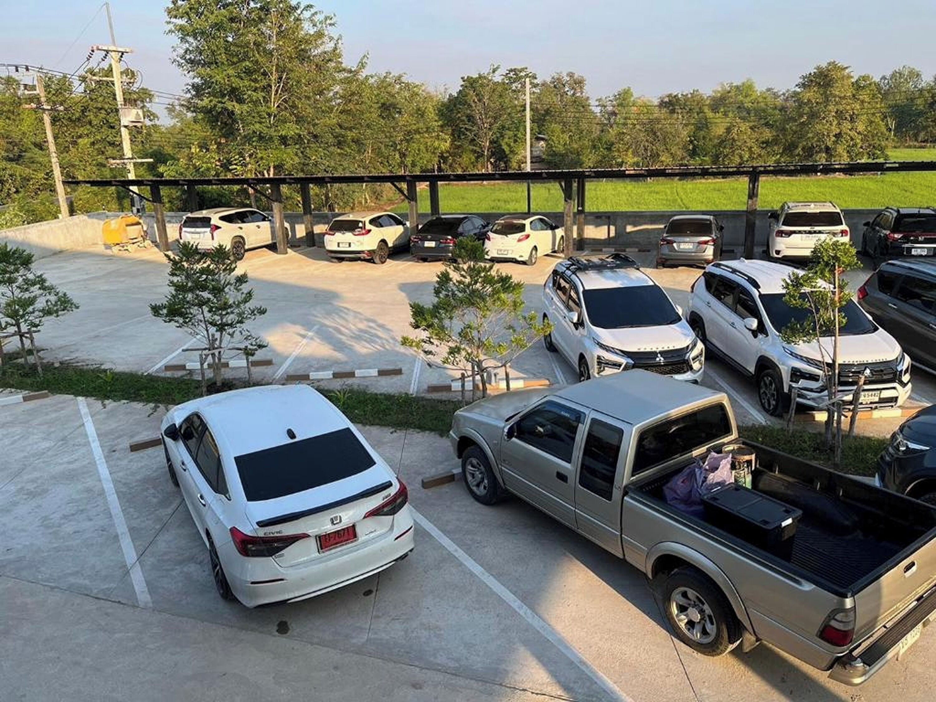 Um estacionamento com vários carros e uma caminhonete.