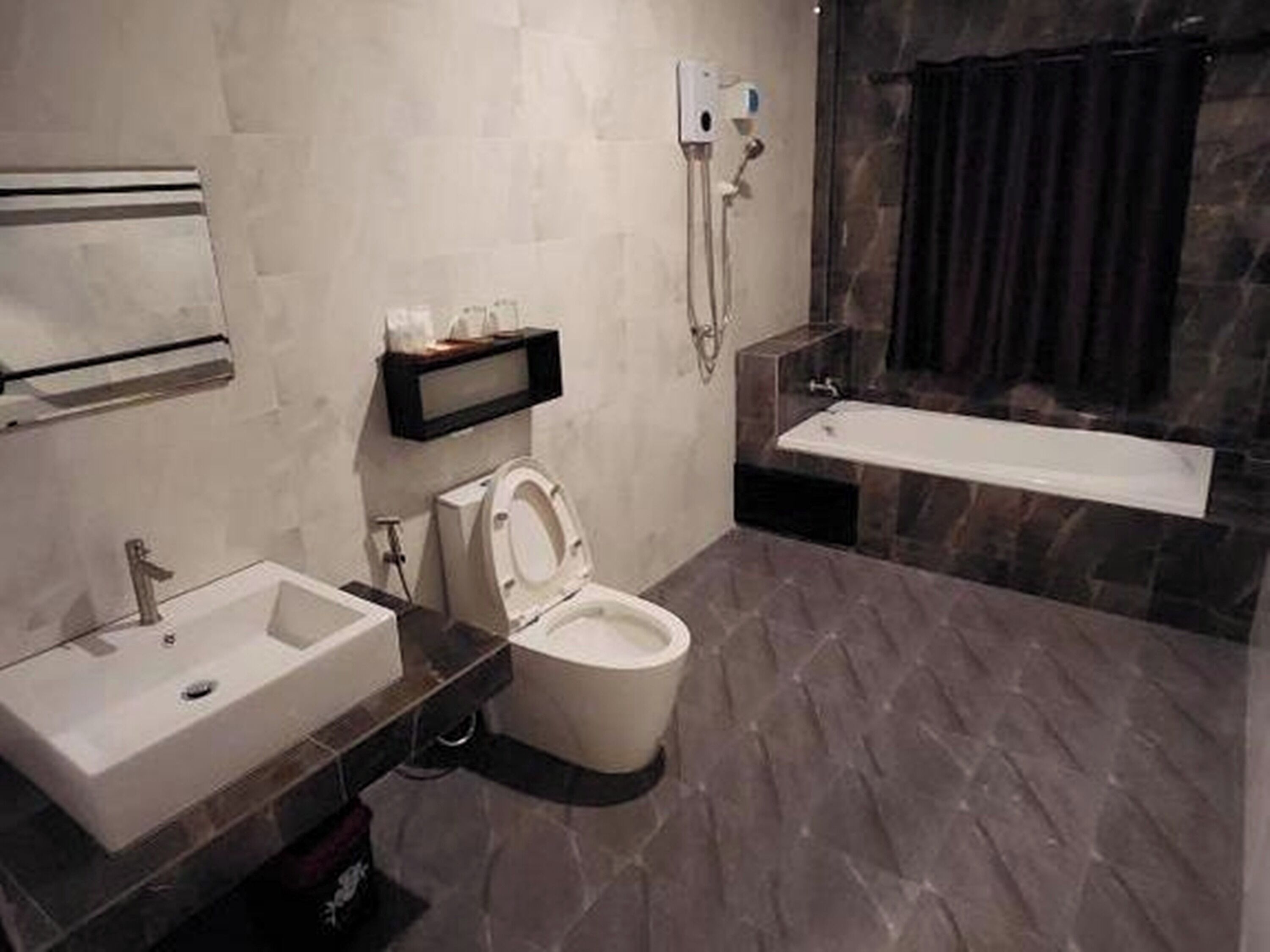 A modern bathroom with a toilet, sink, and bathtub.