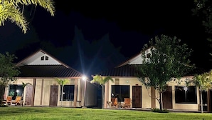 A two-story building with a flat roof, large windows, and a well-maintained lawn.