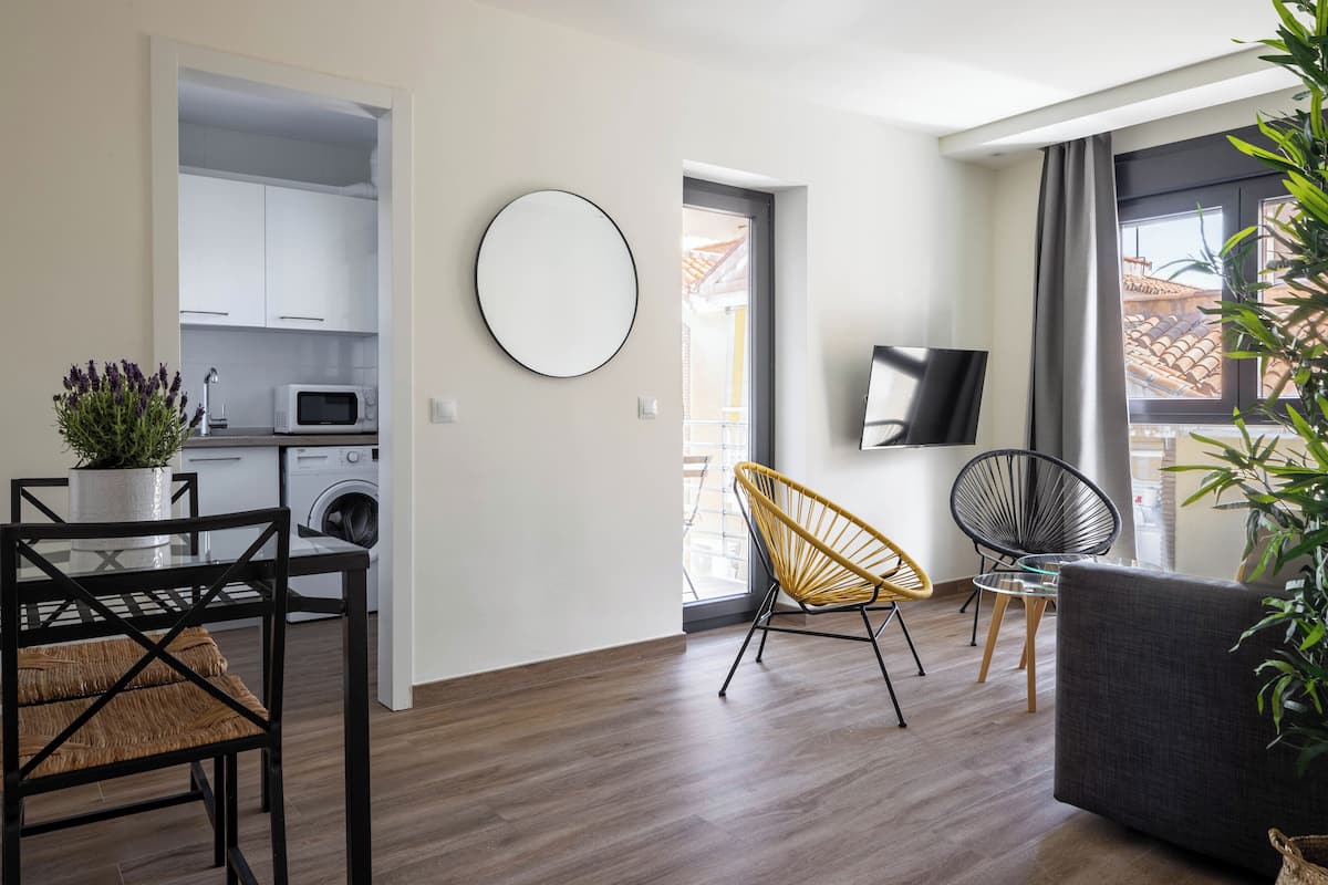 A modern apartment with a kitchen, dining area, and living room.