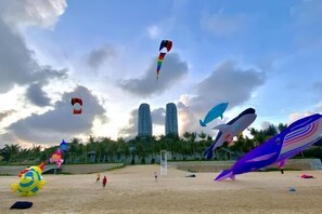 A beach with large inflatable animals and a clear sky.