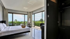 A modern hotel room with a large bed, a small table, a chair, and a view of the outdoors. - Eco Villa, Sea View, Lamai Koh Samui (Koh Samui)
