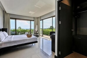 A modern hotel room with a large bed, a small table, a chair, and a view of the outdoors. - Eco Villa, Sea View, Lamai Koh Samui (Koh Samui)