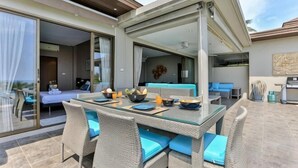 A dining area with a glass table and wicker chairs, a bedroom with a bed and curtains, and a living area with a sofa and coffee table. - Eco Villa, Sea View, Lamai Koh Samui (Koh Samui)