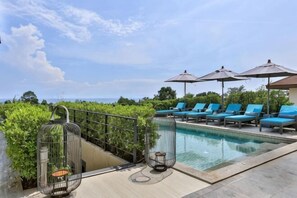 A pool area with lounge chairs and umbrellas, surrounded by greenery and overlooking a body of water. - Eco Villa, Sea View, Lamai Koh Samui (Koh Samui)