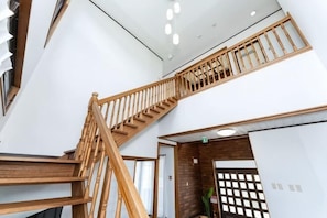A wooden staircase with a railing leading to a higher floor. - Mizunowa (Nago)