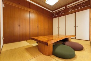 A tatami mat room with a low wooden table and cushions. - Mizunowa (Nago)