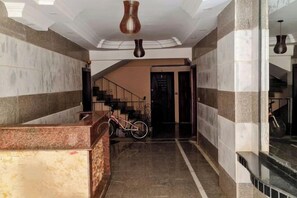A hotel lobby with a reception desk, a staircase, and a bicycle. - RD The Residence Serviced Apartment, New Cairo Prime Location (New Cairo City)