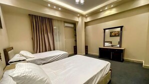 A hotel room with two beds, a vanity with a mirror, and a window with curtains. - RD The Residence Serviced Apartment, New Cairo Prime Location (New Cairo City)