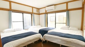 A room with two beds, a window, and a wooden floor. - SunStay Osaki I (Tokyo)