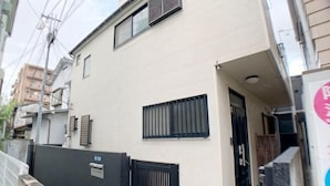 A building with a black gate, a black door, and a small window. - SunStay Osaki I (Tokyo)