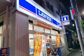 A storefront with a sign that reads 'LAWSON' and a blue and white sign above it. - SunStay Osaki I (Tokyo)