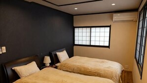 A room with two beds, a window with a grid pattern, and an air conditioner on the wall. - [Family-Friendly] Kyoto House, Walk to Gion (Kyoto)