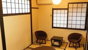 A traditional Japanese room with tatami flooring, two dark armchairs, a small table, and a low wooden cabinet. - [Family-Friendly] Kyoto House, Walk to Gion (Kyoto)