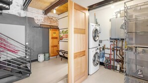 A laundry room with a washing machine, stacked drying racks, and visible plumbing. - Downtown•Near River, Trails & Shopping (Salida)