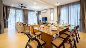 Un coin repas avec une table en bois, des chaises et un ventilateur de plafond.