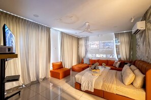 Un salon moderne avec un ensemble de canapés, une table basse et un téléviseur fixé au mur.