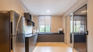 Une cuisine moderne équipée d’un réfrigérateur, de placards et d’une fenêtre.